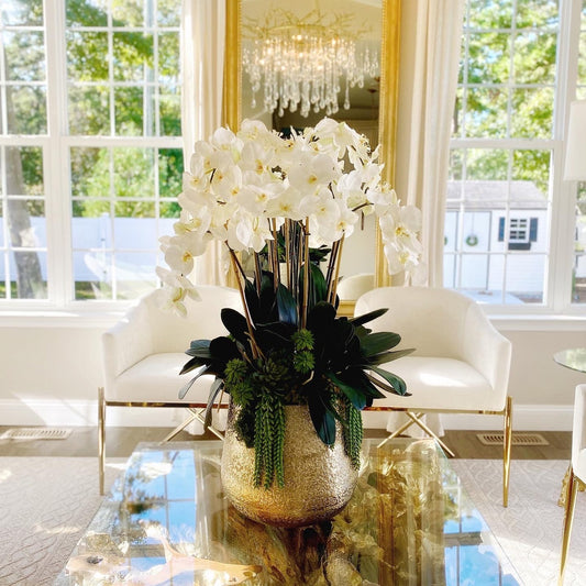 Vase Delaney doré avec plusieurs tiges d’orchidées Phalaenopsis et de plantes succulentes