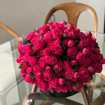 Roses anglaises rose foncé dans vase en verre noir