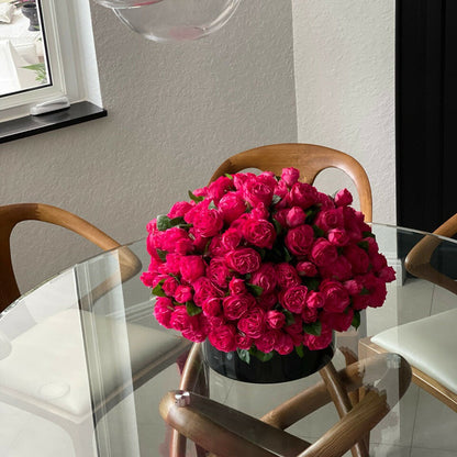 Roses anglaises rose foncé dans vase en verre noir