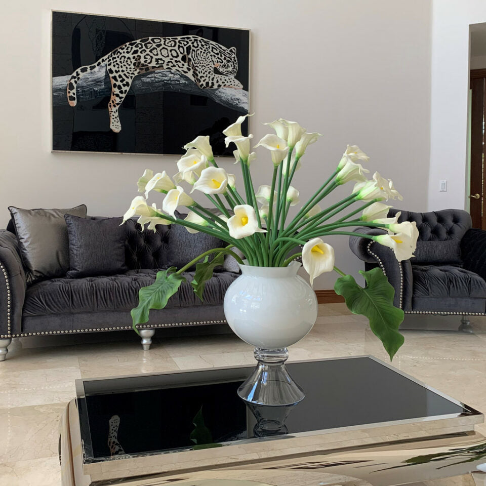 Vase élégant avec plusieurs arums blancs